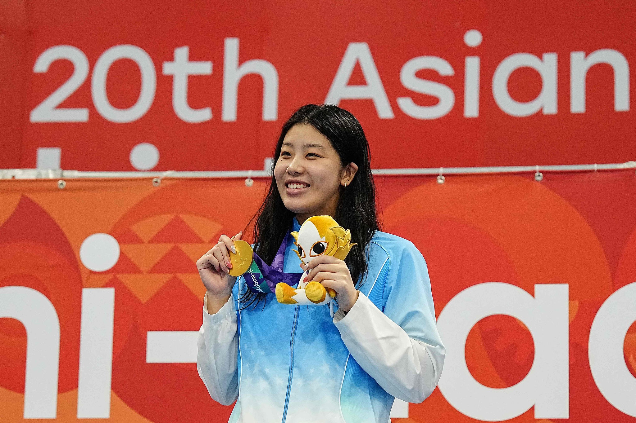 China's Wu Qingfeng displays her gold medal after winning the women's 50-meter freestyle final at the 2026 Aichi-Nagoya Asian Games in Tokyo, Japan, September 24, 2026. /VCG