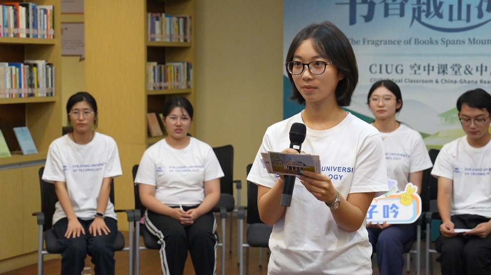 A Zhejiang University of Technology student reads her postcard message aloud to Ghanaian students. /Photo by Yao Jieyang