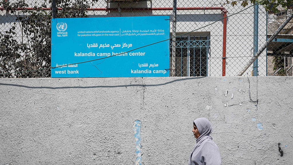 A Palestinian woman walks past the Kalandia camp health center at the Kalandia refugee camp, south of the Israeli-occupied West Bank city of Ramallah, August 27, 2026. /VCG