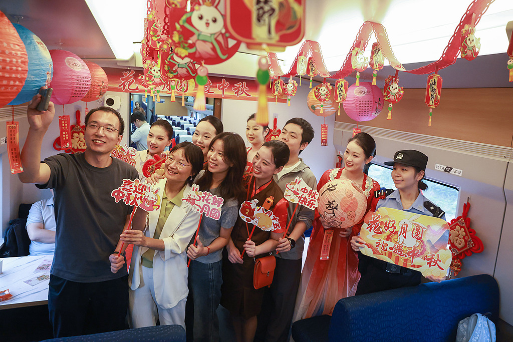 Train staff and passengers take part in a Mid-Autumn Festival-themed event celebrating reunion aboard a train from Hankou Station to Yichang East Station, September 23, 2026. /VCG