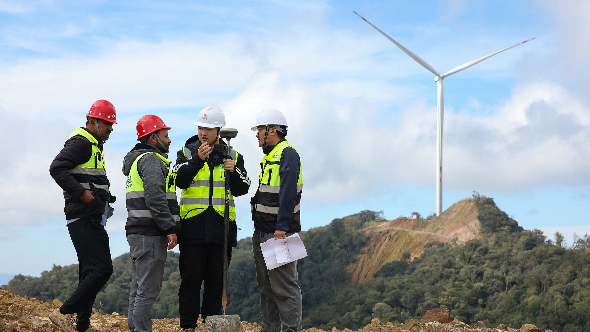 Chinese and foreign engineers exchange views at the 600-MW Monsoon Wind Power Project in southern Laos, December 28, 2025. /VCG