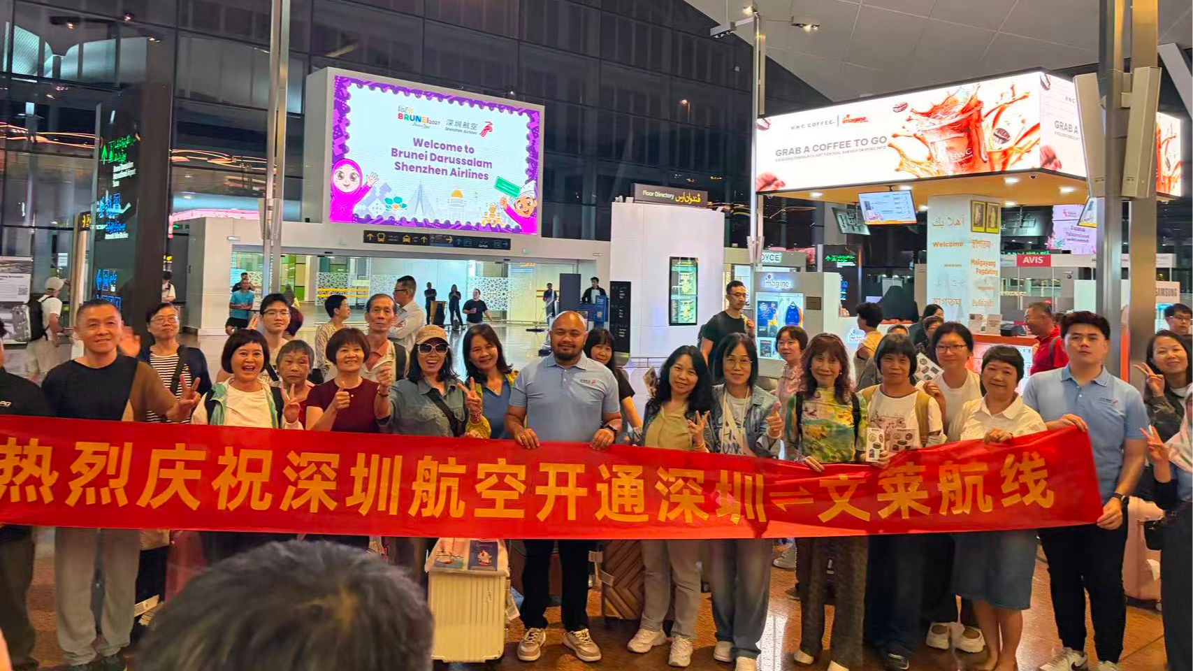 Travelers pose with a banner celebrating the launch of Shenzhen Airlines' direct Shenzhen–Brunei service at Brunei International Airport. /CMG