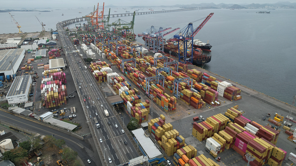 An aerial view shows port terminals and storage facilities where containers remain stacked as exporters face uncertainty over shipments destined for the US market following the implementation of new tariffs imposed by the United States on Brazilian products, Rio de Janeiro, Brazil, August 25, 2026. /VCG