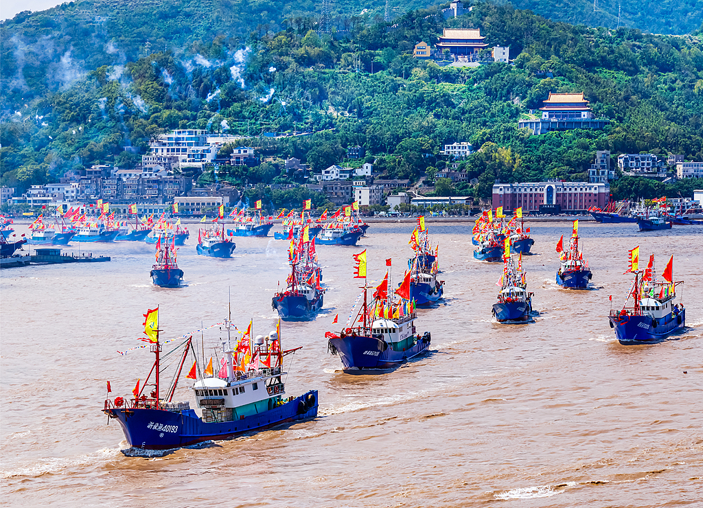 Fishing boats leave the harbor as fishermen begin making the 