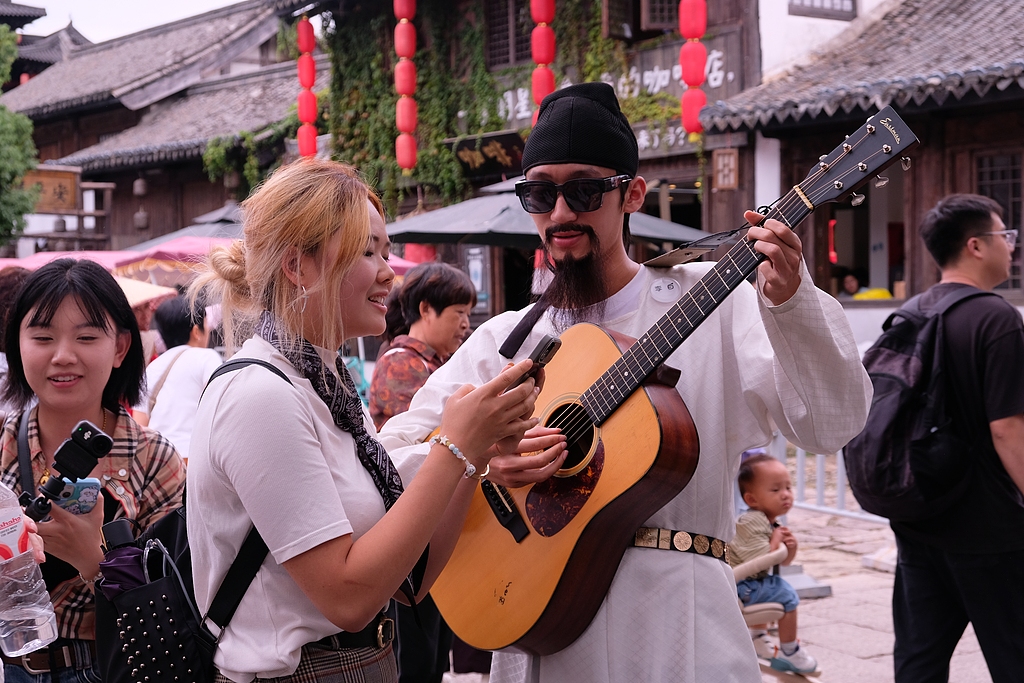 Tourists sing along with an NPC actor, Xiangshan County, Zhejiang Province, east China, October 2, 2026. /CFP