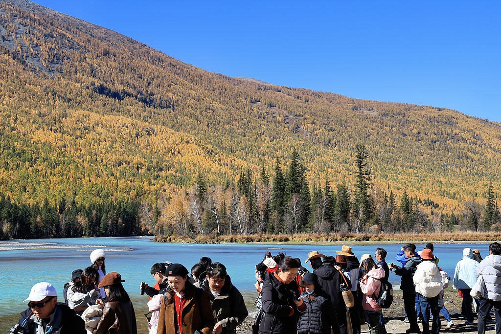 Visitors admire the autumn scenery at Kanas Scenic Area in Altay Prefecture, northwest China's Xinjiang Uygur Autonomous Region, September 30, 2026. /VCG
