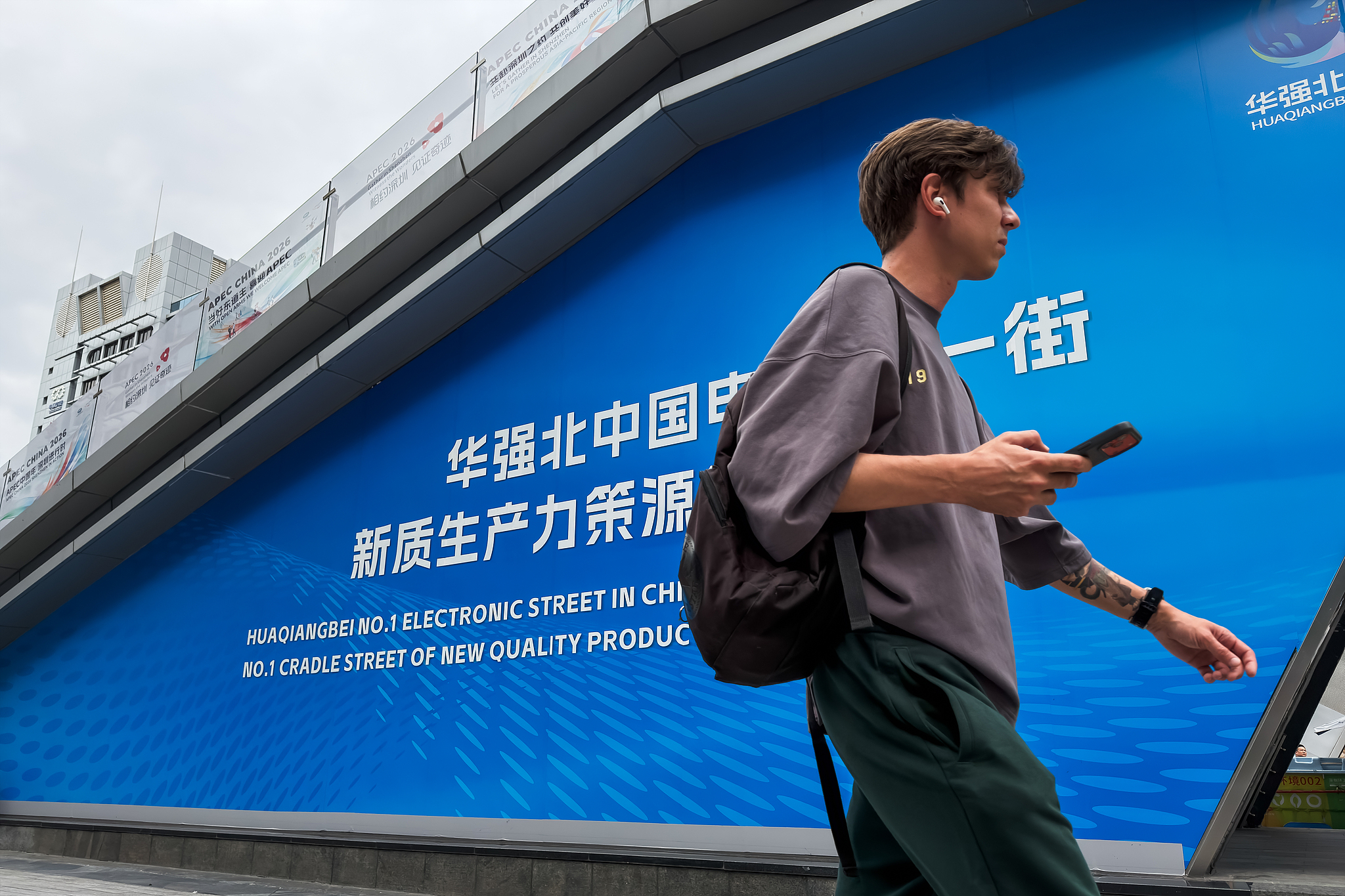 A foreign visitor walks past signage in the Huaqiangbei electronics district market, Shenzhen, Guangdong Province, south China, September 3, 2026. /VCG
