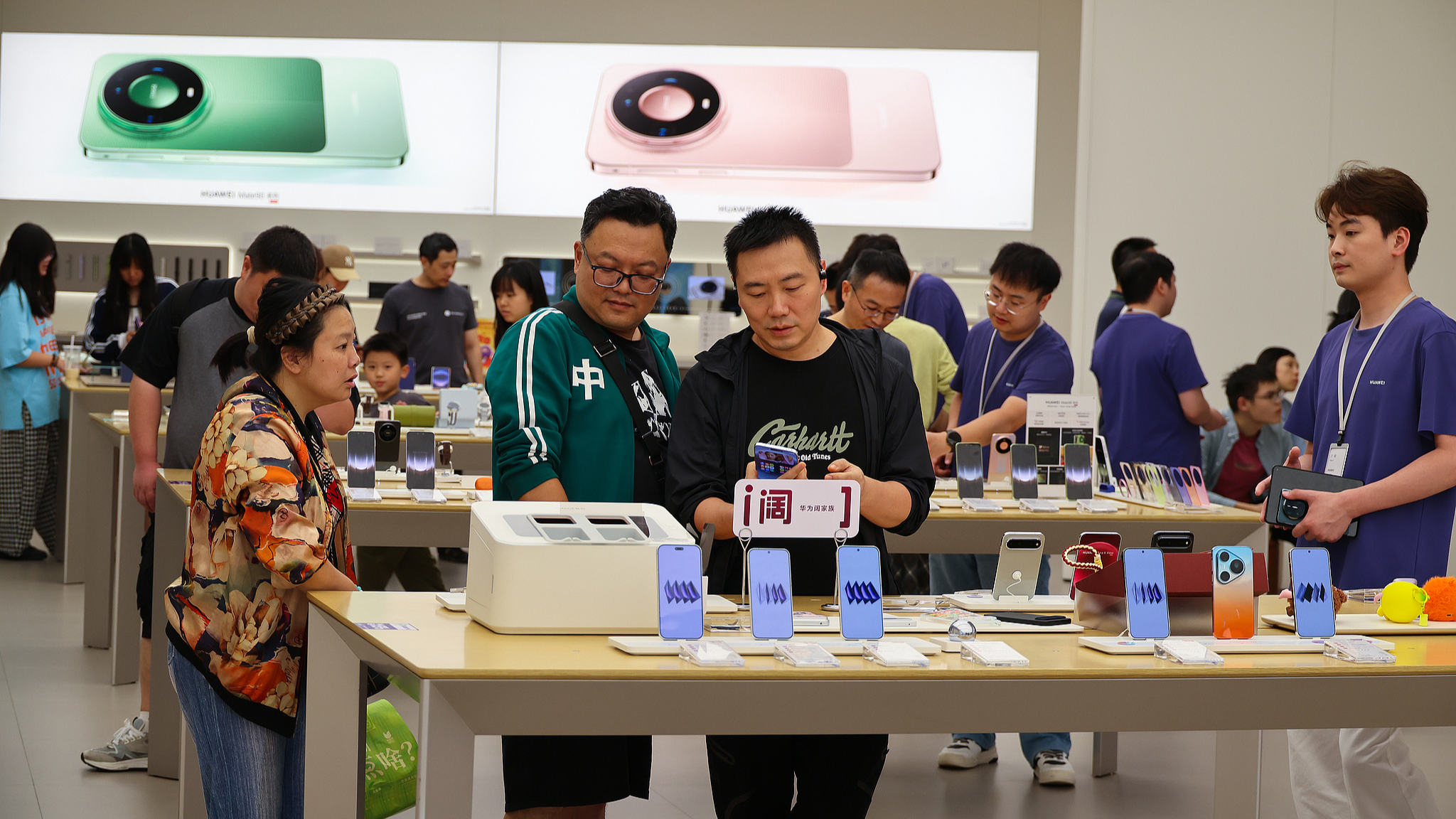 Customers try out Huawei Mate 90 series smartphones at a Huawei store in Shanghai, east China, as shopping malls see strong consumer activity during the National Day holiday, October 2, 2026. /VCG
