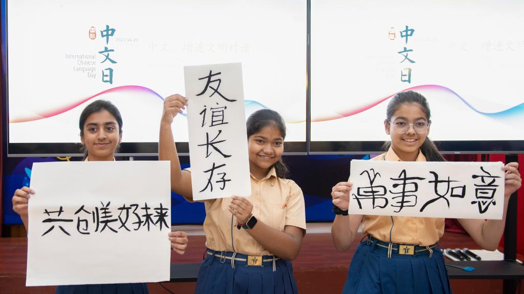 Indian students pose for photos with their Chinese calligraphy in New Delhi, India, April 20, 2023. /Xinhua