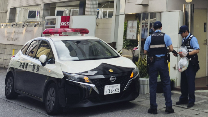 Police officers and a police car are seen outside a hotel in Naha, Okinawa Prefecture, Japan. /CMG