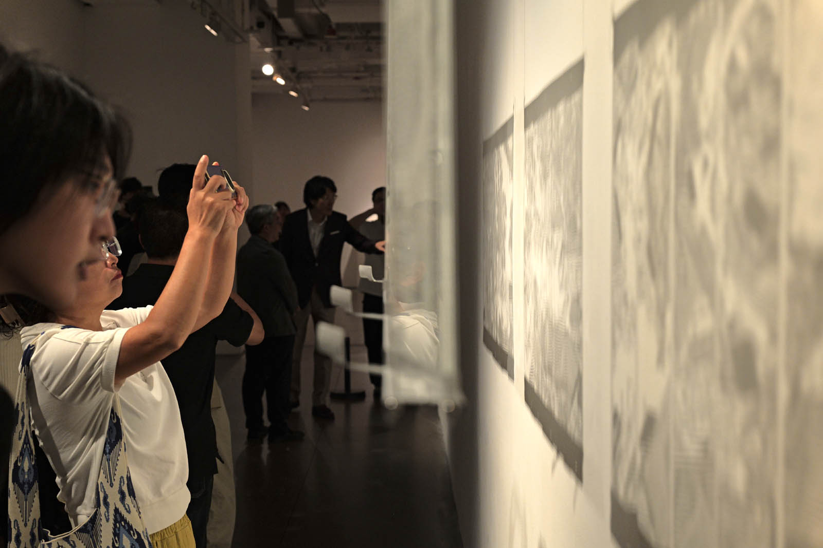 Visitors take pictures at the ongoing “Chinese Contemporary Glass Art Exhibition,” which runs from September 20 to November 1, 2026, at Today Art Museum in Beijing. /CGTN
