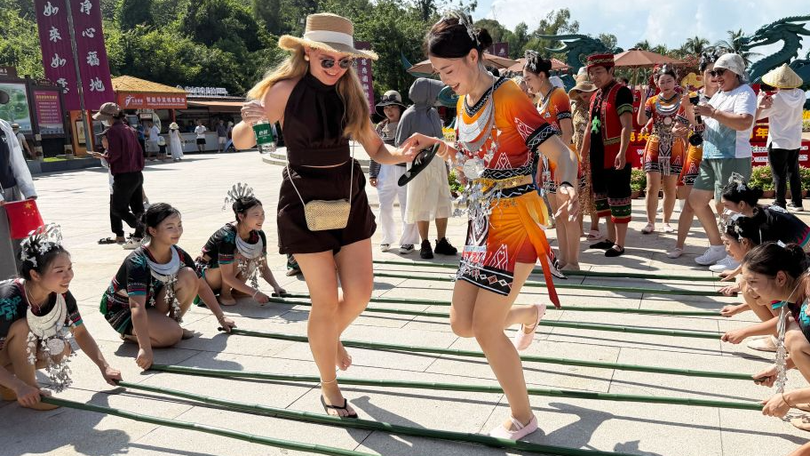 A foreign tourist tries bamboo pole dance at a scenic area in Sanya, south China's Hainan Province, October 1, 2026. /Xinhua
