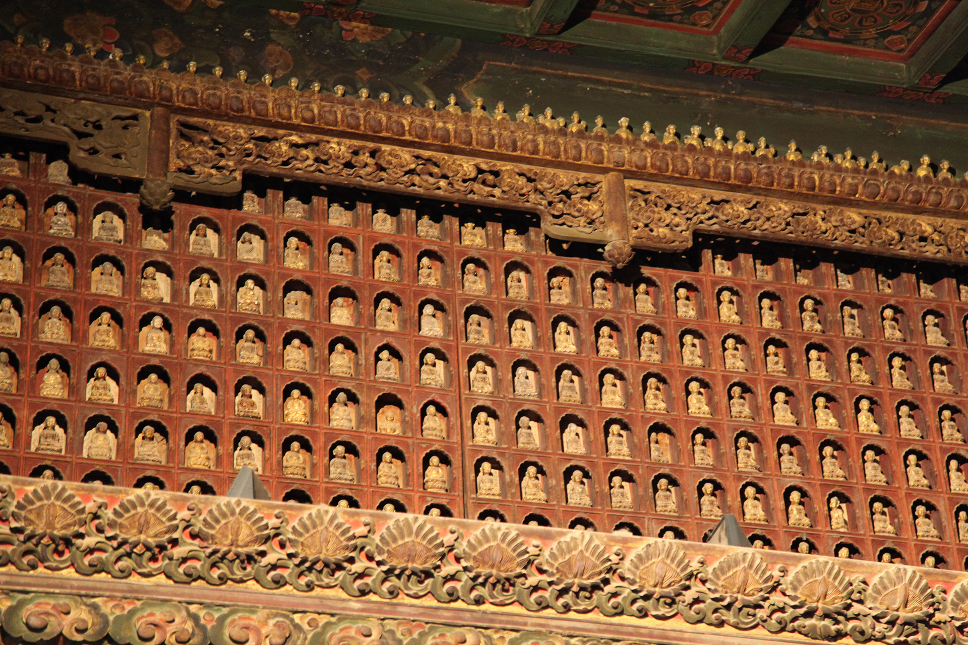 Buddhist figures set into small niches are seen in the Tathagata Hall of the Zhihua Temple in Beijing. /CGTN