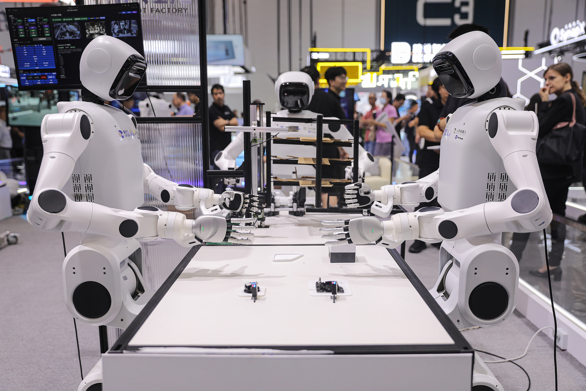 Humanoid robots work collaboratively on a platform at the 2026 World Robot Conference in Beijing, China, August 20, 2026. /VCG
