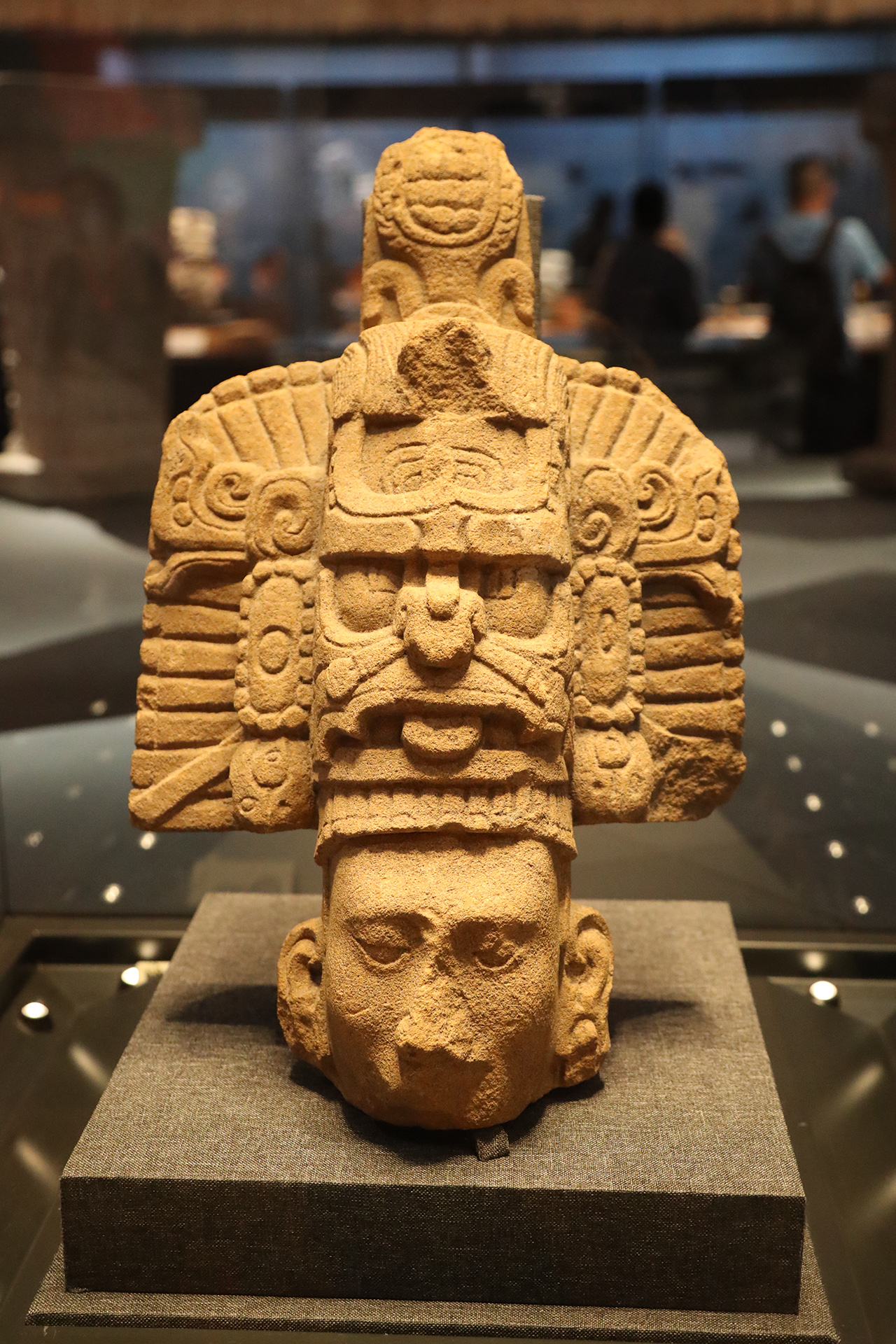 A sandstone head with a cosmic tree headdress is seen on display at the 