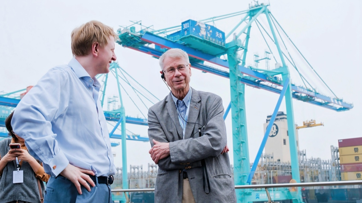 Jaakko Laakso, former member of the Finnish Parliament, talks with Mark Logan, former legislator of the UK Parliament at Tianjin Port, October 12, 2026. 