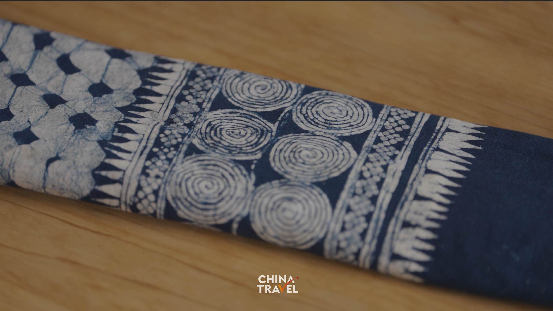 Bouyei artisans use wax to create intricate patterns on cloth before dyeing it indigo blue. /CGTN