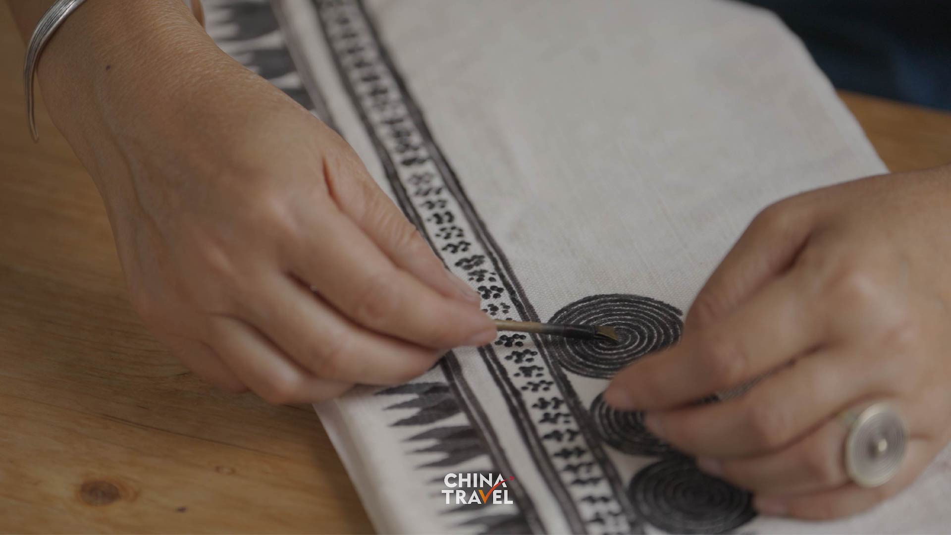 Bouyei artisans use wax to create intricate patterns on cloth before dyeing it indigo blue. /CGTN