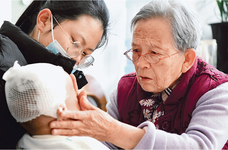 Lu Shengmei (right) provides a free medical consultation to a child at her home in Jiaxian County, Yulin, Shaanxi Province, November 16, 2022. /Xinhua