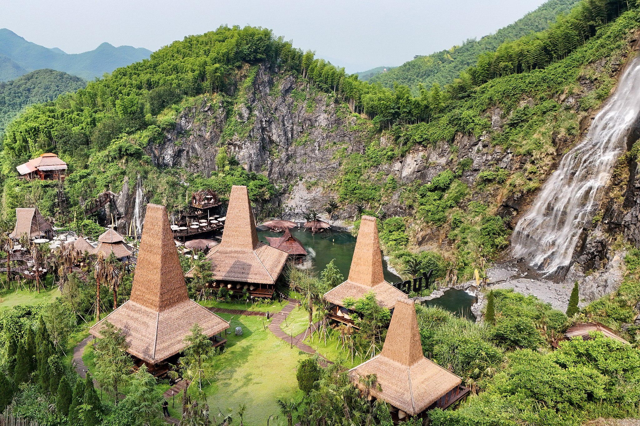 Tourists take photos and explore a waterfall cafe built on a former mining site in Anji County, Huzhou, Zhejiang Province, June 4, 2026. /VCG 