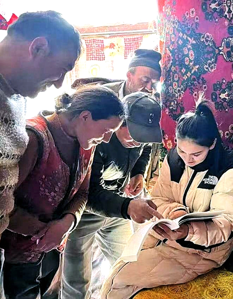 Guzailinuer Abula (left) talks with local residents. /Tianshannet