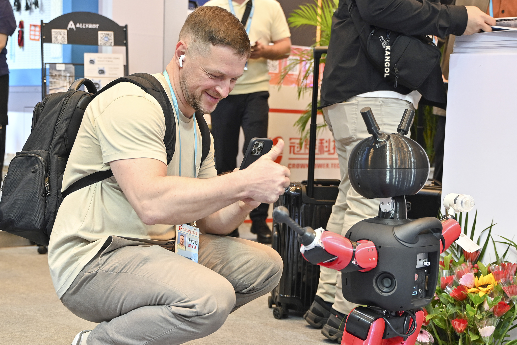 An overseas buyer interacts with a robot during the Canton Fair in Guangzhou, south China's Guangdong Province, October 15, 2026. /VCG