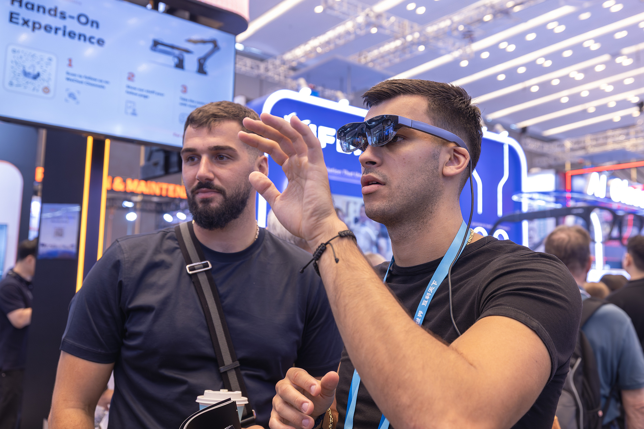 An overseas buyer tries out smart glasses in the service robot zone at the Canton Fair in Guangzhou, south China's Guangdong Province, October 17, 2026. /VCG