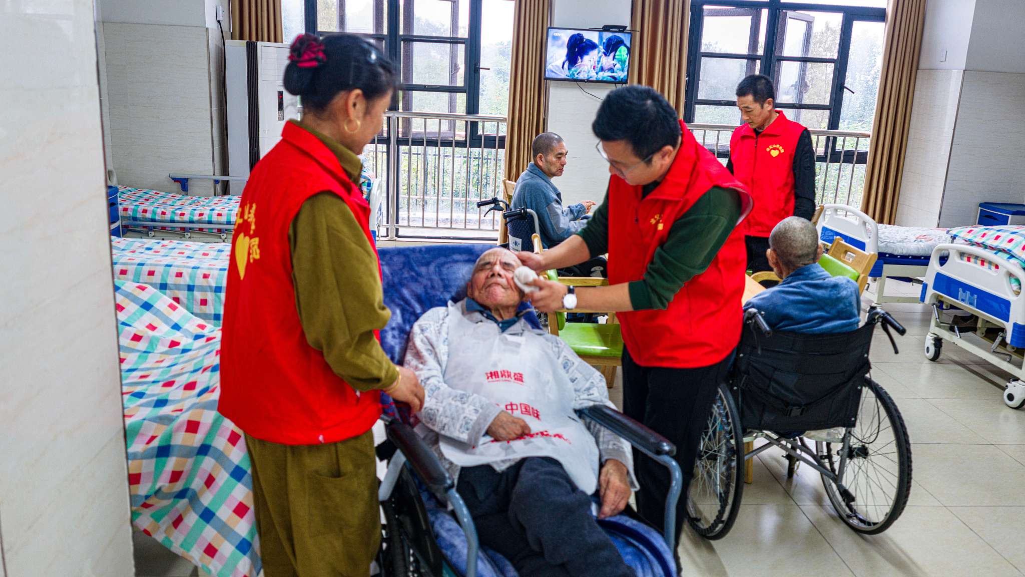 Kong Xingyu (C), head of the Yefushan Town Elderly Care Service Center in Lujiang County, east China's Hefei Province, leads staff in providing daily care to residents with disabilities in a special care ward, October 18, 2026. /VCG