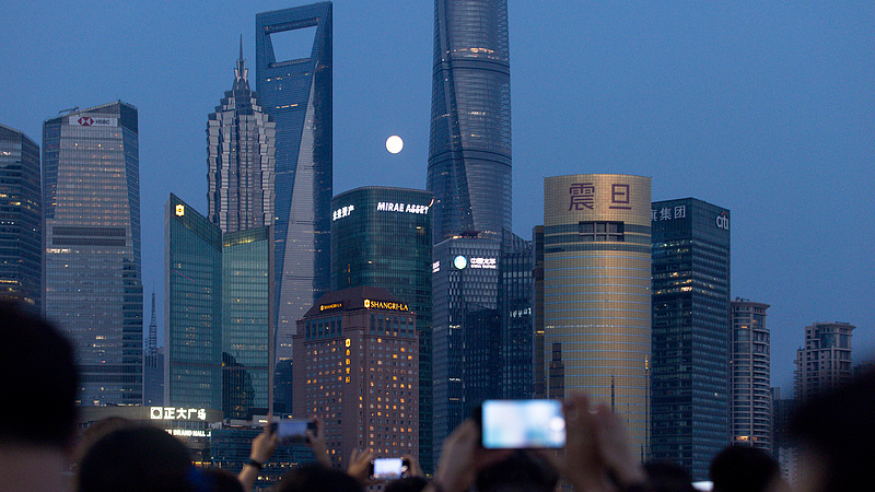 A full moon rose slowly between the buildings in Lujiazui, Shanghai, attracting a large number of tourists to take photos and check in, Shanghai, China, September 25, 2026./VCG