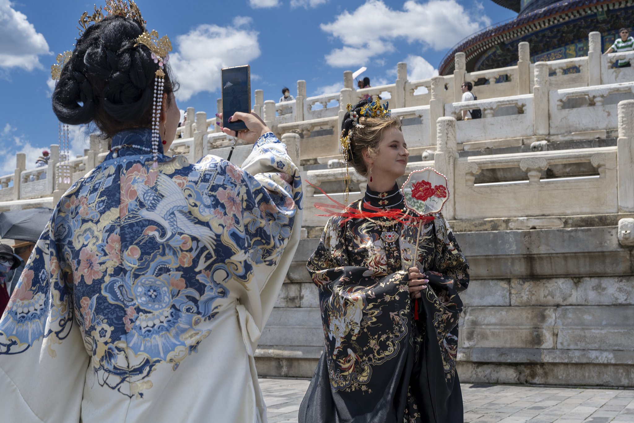 Tourists wearing traditional Chinese attire take photos for each other at the Temple of Heaven, in Beijing, China, June 9, 2026. /VCG
