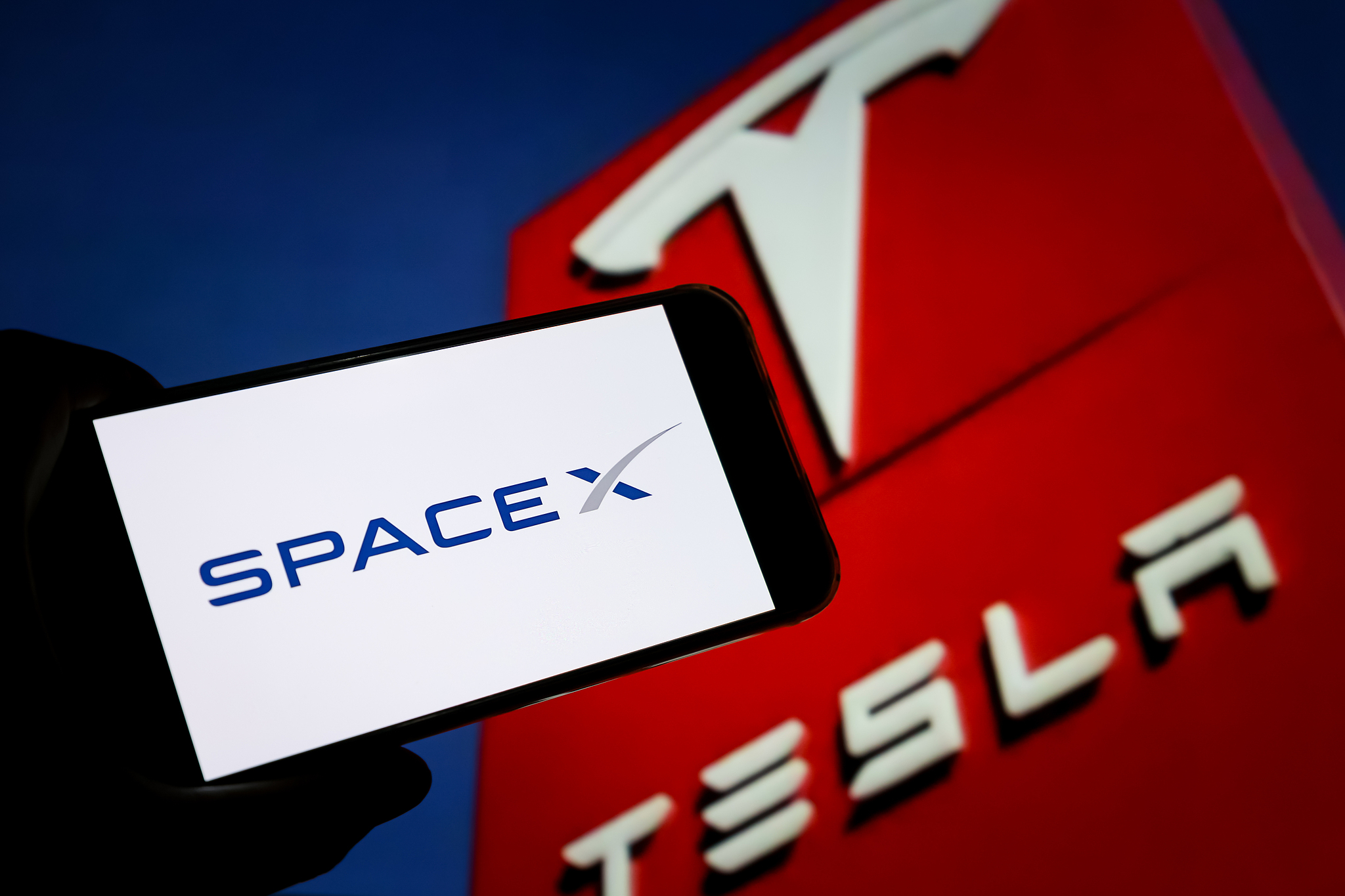 Corporate logos of Elon Musk's flagship companies, SpaceX and Tesla. /VCG
