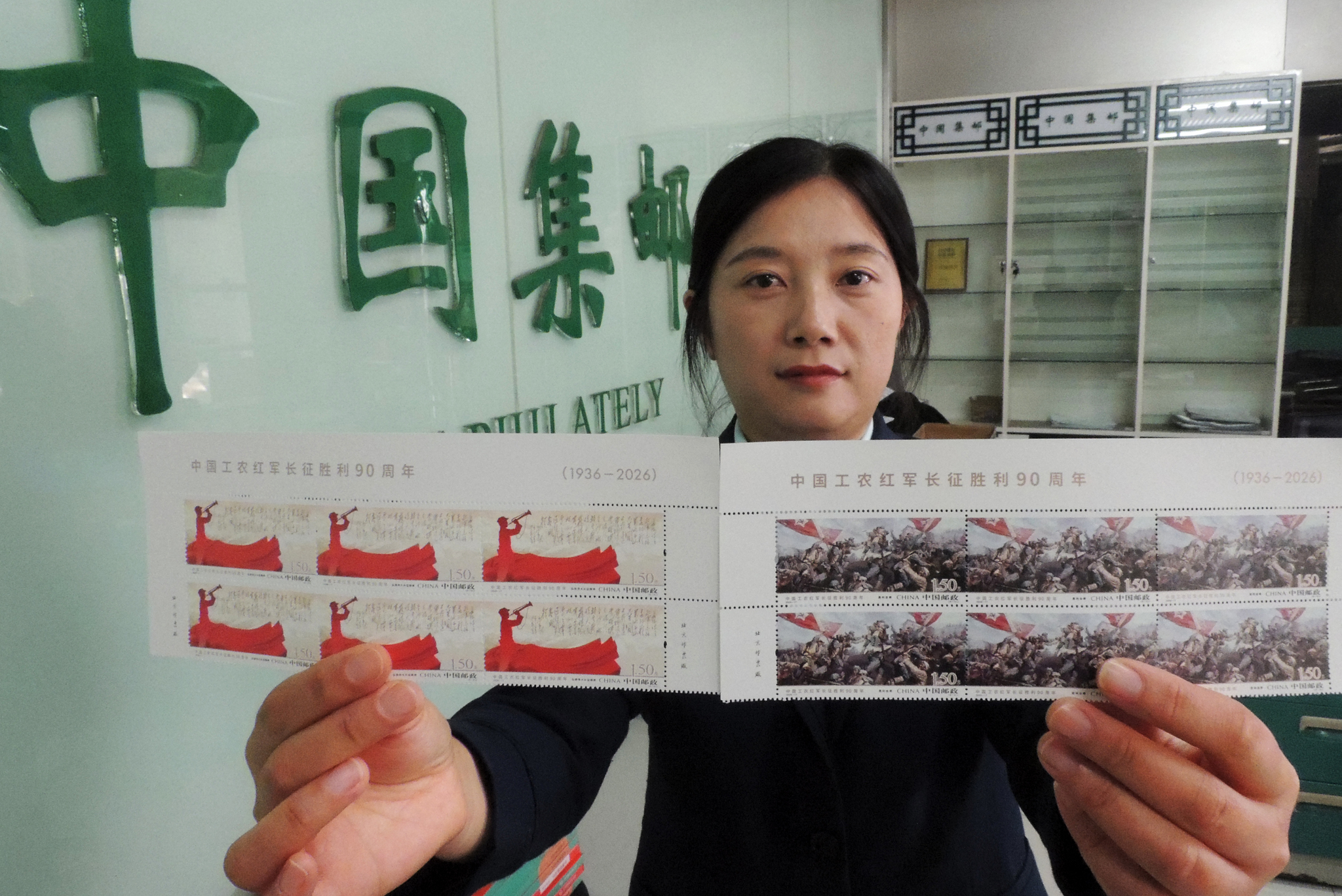 A staff member at the China Philately shop in Lianyungang, east China's Jiangsu Province, shows off the newly issued set of commemorative stamps on October 22, 2026. /VCG
