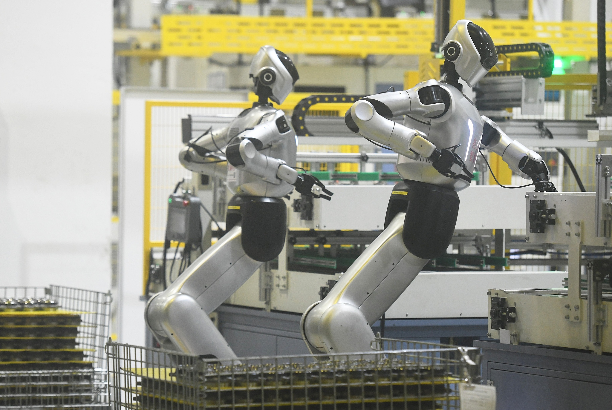 Humanoid robots pick up components on a production line in Hangzhou, Zhejiang Province, east China, October 19, 2026. /VCG