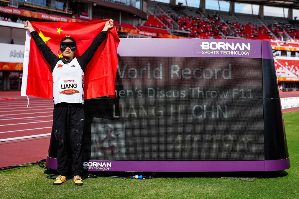 China's Liang Hongxia poses in front of a board displaying her new world record of 42.19 meters after winning the women's discus F11 gold medal at the 2026 Aichi-Nagoya Asian Para Games in Nagoya, Japan, October 21, 2026. /Xinhua