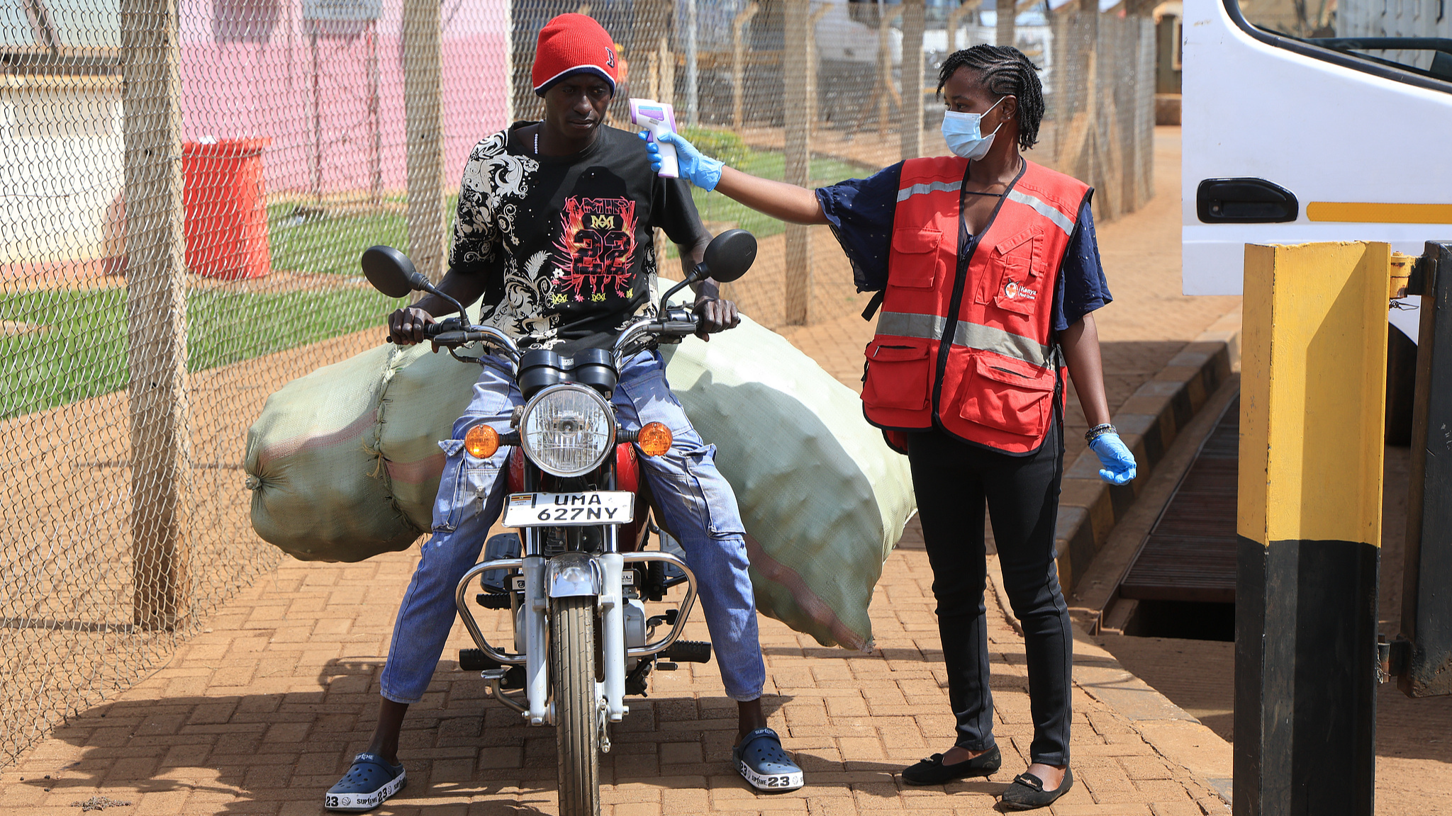 A Kenyan health worker checks the temperature of a traveler crossing from Uganda to Kenya as part of measures to contain the spread of Ebola virus, in Busia, Kenya, October 15, 2026. /VCG