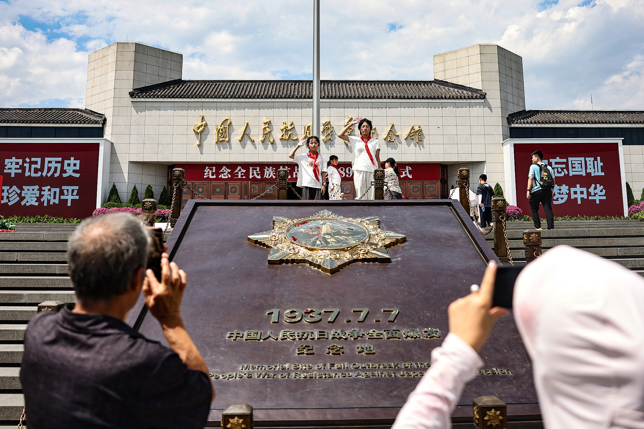 Children salute in front of the Museum of the Chinese People's War of Resistance Against Japanese Aggression in Beijing, China, July 7, 2026. /VCG