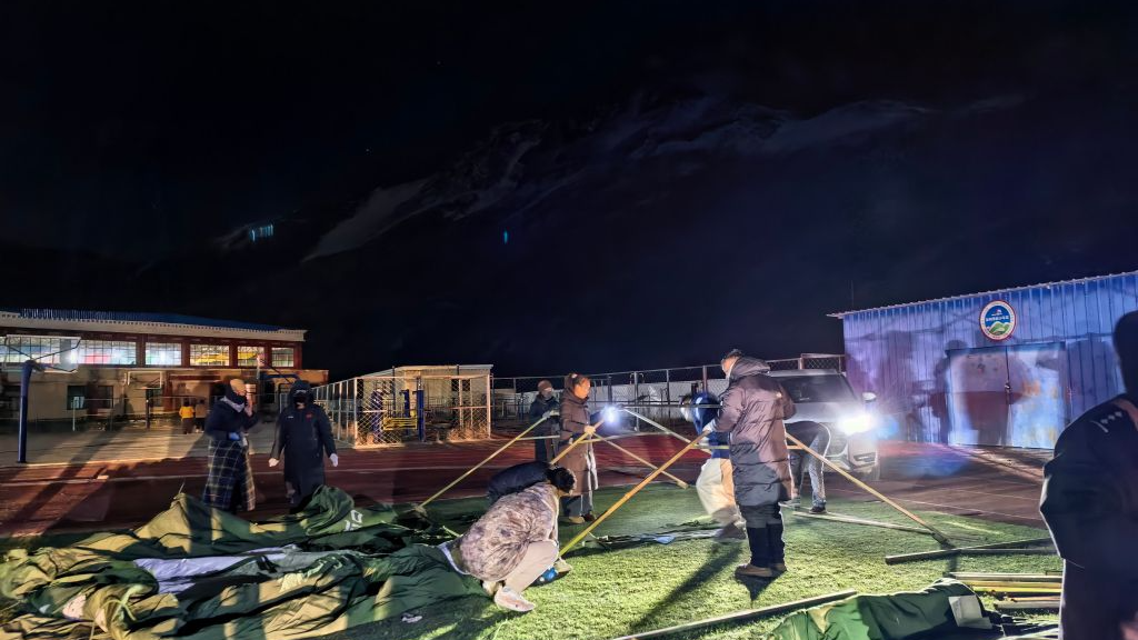 Local officials and residents set up emergency tents on the playground of an elementary school in Baqen County, Nagqu City, southwest China's Xizang Autonomous Region, October 23, 2026. /Xinhua