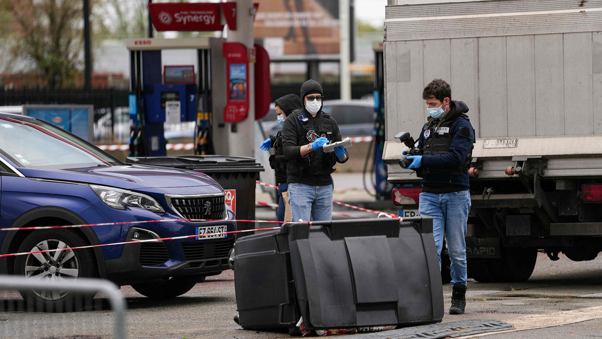 Police officers look at evidence at petrol station where a man opened fire from his car, killing one person and injuring four others according to police sources, in Trappes, Paris' suburb, October 23, 2026. /VCG