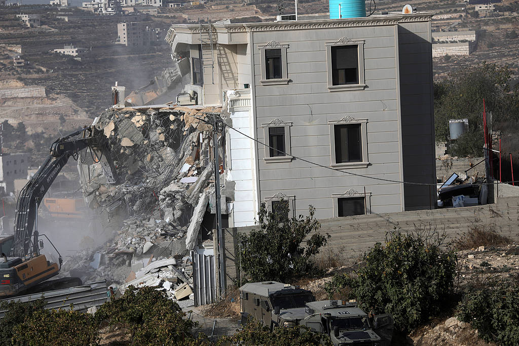 Israeli military vehicles demolish a Palestinian house near the site of a shooting incident in Hebron, in the southern occupied West Bank, October 23, 2026. /VCG