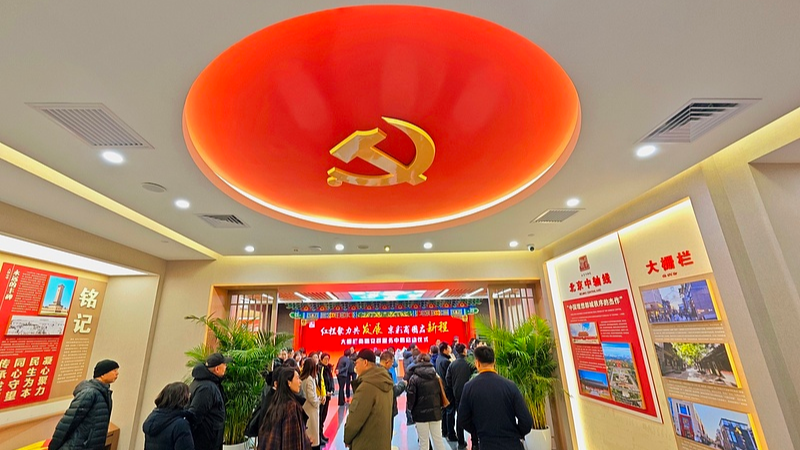 Visitors tour the Dashilan Beijing Fang Business Circle Party-Mass Service Center, a community-level governance and public service hub in Beijing's Xicheng District, China, December 10, 2025. /VCG