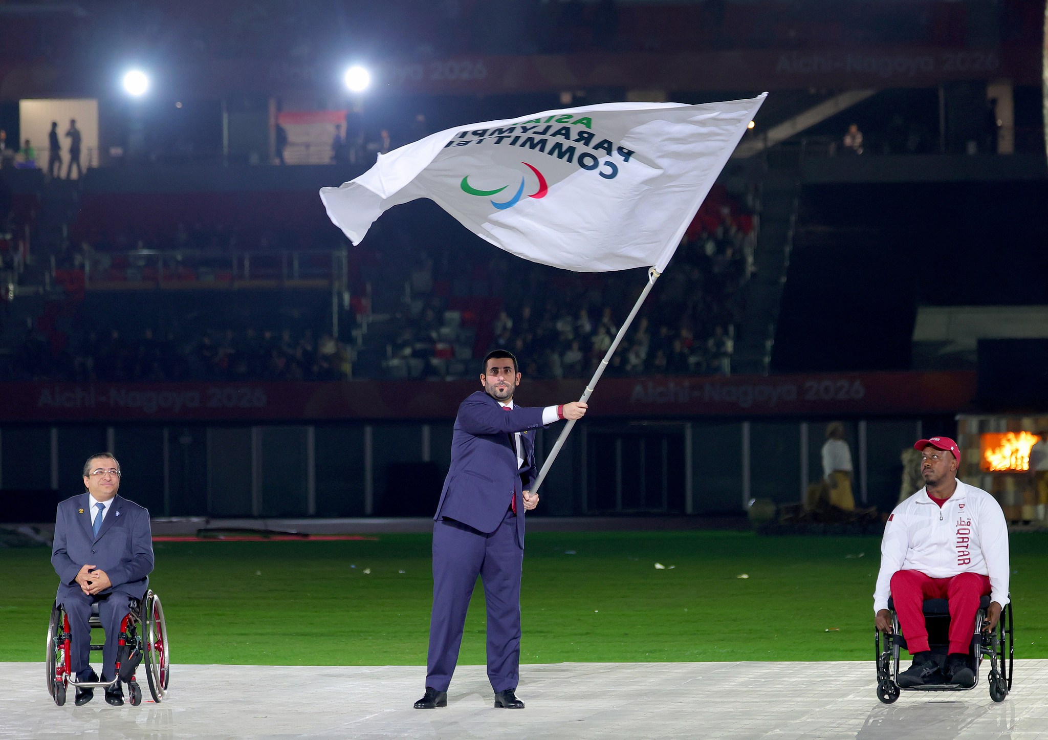 Ahmad Abdulla Al Buenain, CEO of the Doha 2030 Asian Games Organizing Committee, waves the Asian Paralympic Committee (APC) flag during the handover ceremony at the closing ceremony of the 2026 Aichi-Nagoya Asian Para Games in Nagoya, Japan, October 24, 2026. /VCG