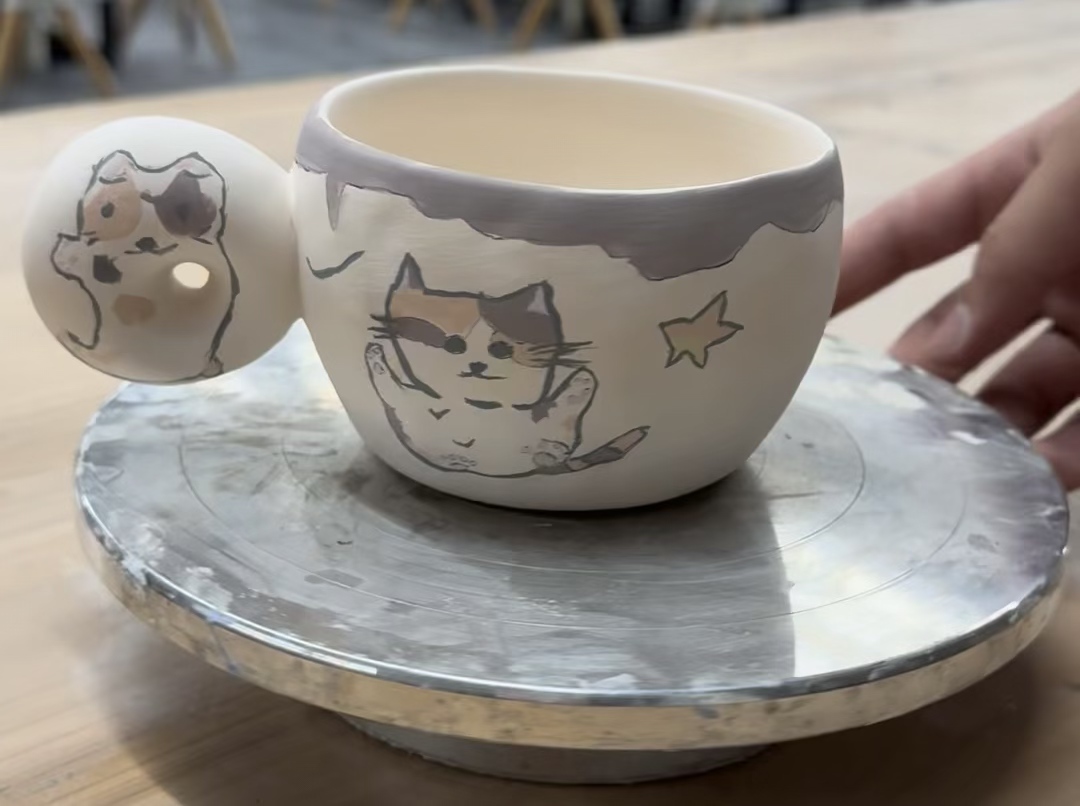 The tri-color cat mug I drew in Jingdezhen. /CGTN