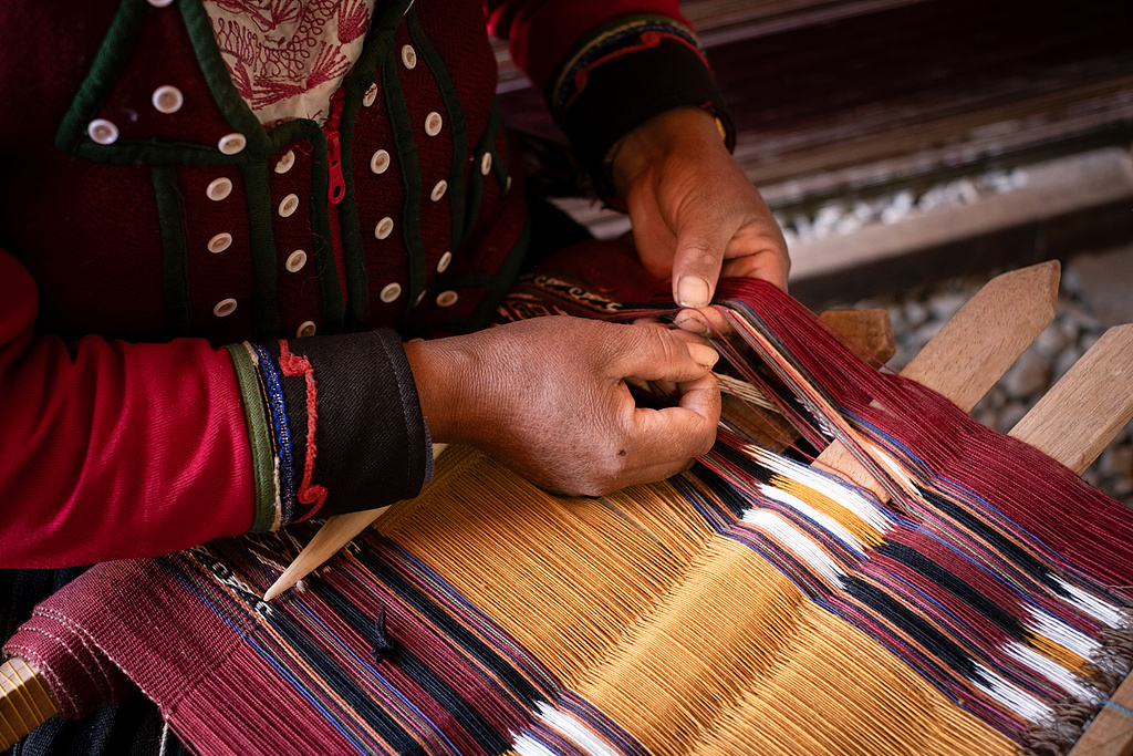 A weaver works on a textile at the Chaska Andina Textile Association in Cusco, Peru, November 20, 2025. /VCG