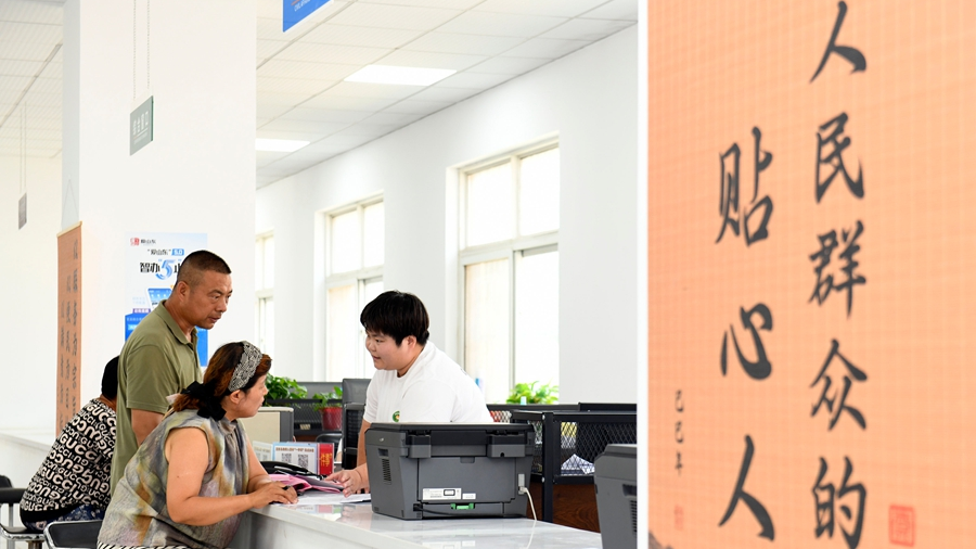 A staff member helps residents apply for government assistance for low-income households at a Party service center in Xiangzhaozhuang Township, Xiajin County, Dezhou City, east China's Shandong Province, July 5, 2026. /Xinhua