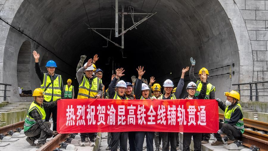 Workers pose for photos to celebrate the completion of track laying at the Junlian tunnel of the Chongqing-Kunming high-speed railway on the border between southwest China's Yunnan and Sichuan provinces, October 24, 2026. /Xinhua