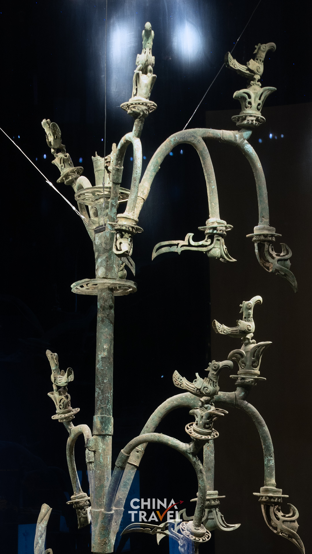 Perched birds and curling branches turn the tree's upper levels into an intricate sculptural world.