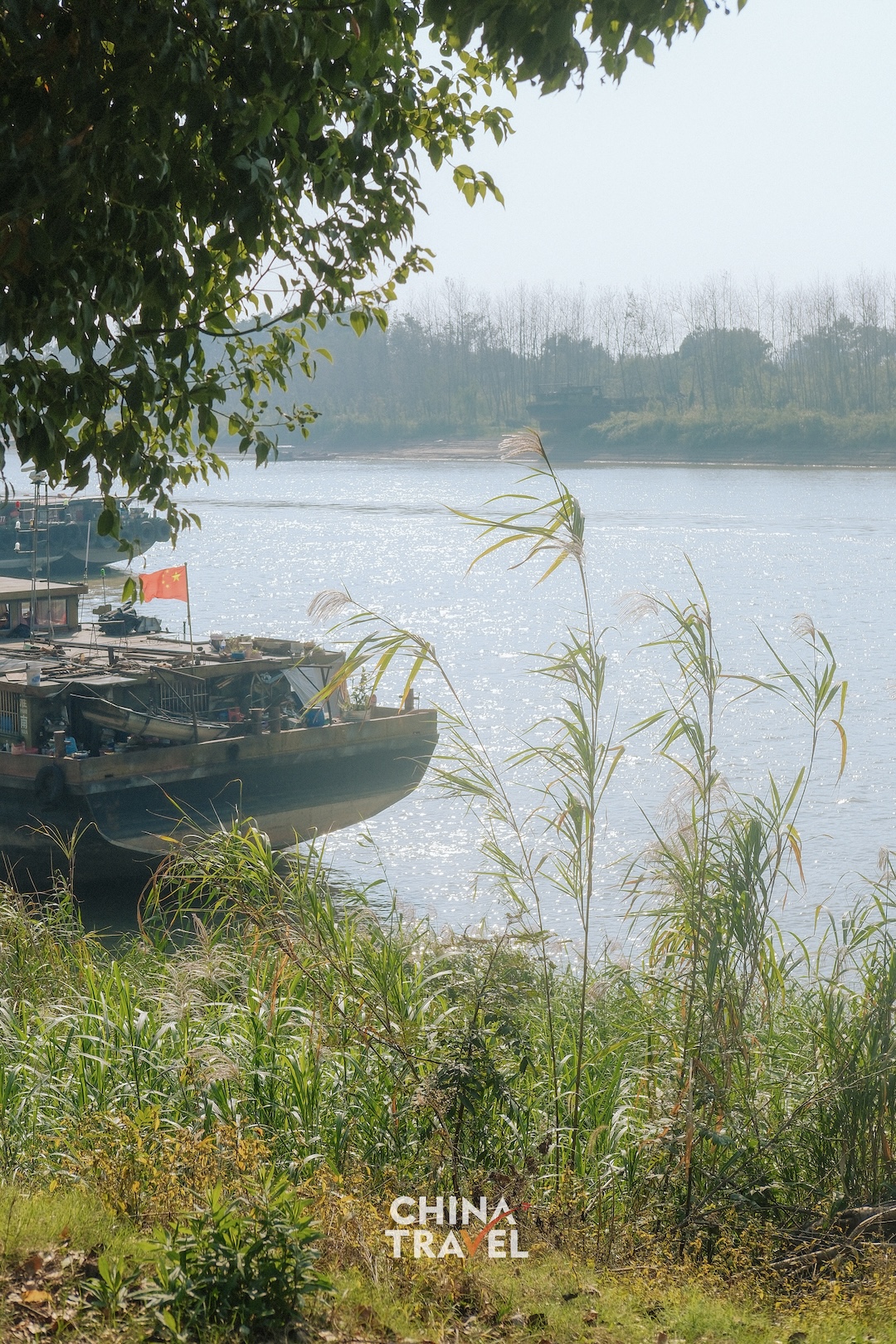 Boats, riverside greenery and people by the landing offer glimpses of an autumn day along the water. /CGTN