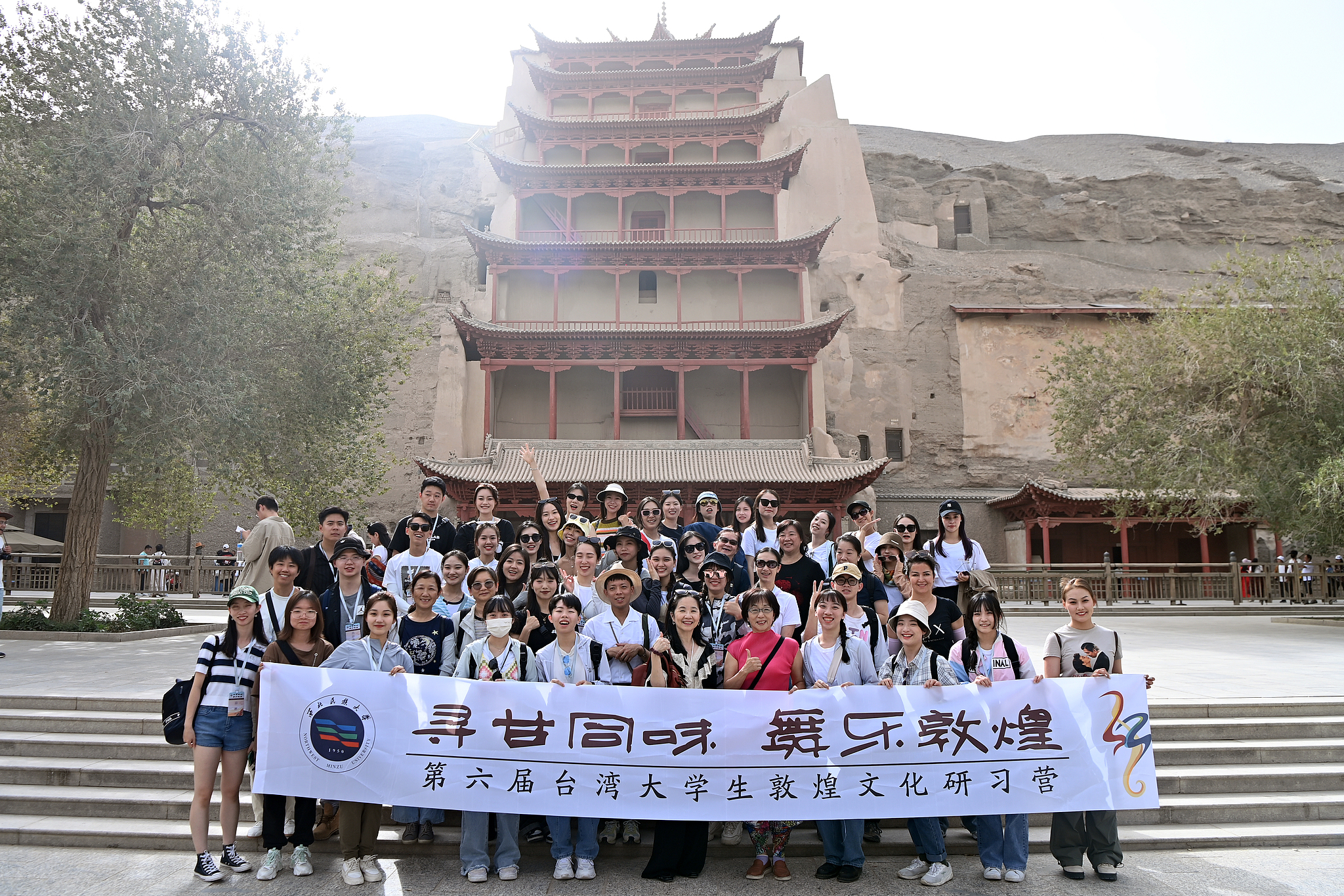 A group of university students from Taiwan on an exchange visit pose for a group photo at the Mogao Caves in Dunhuang, Gansu Province, north China, August 29, 2023. /CFP