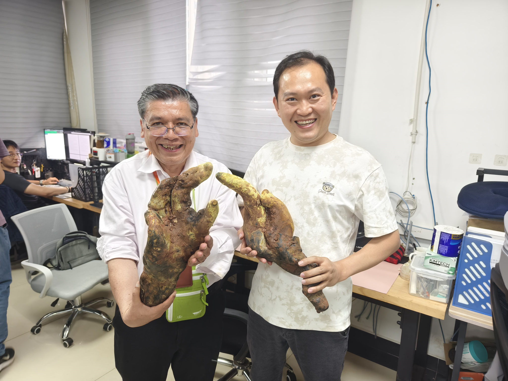 Researchers hold specimens of Dianjunus rex. 