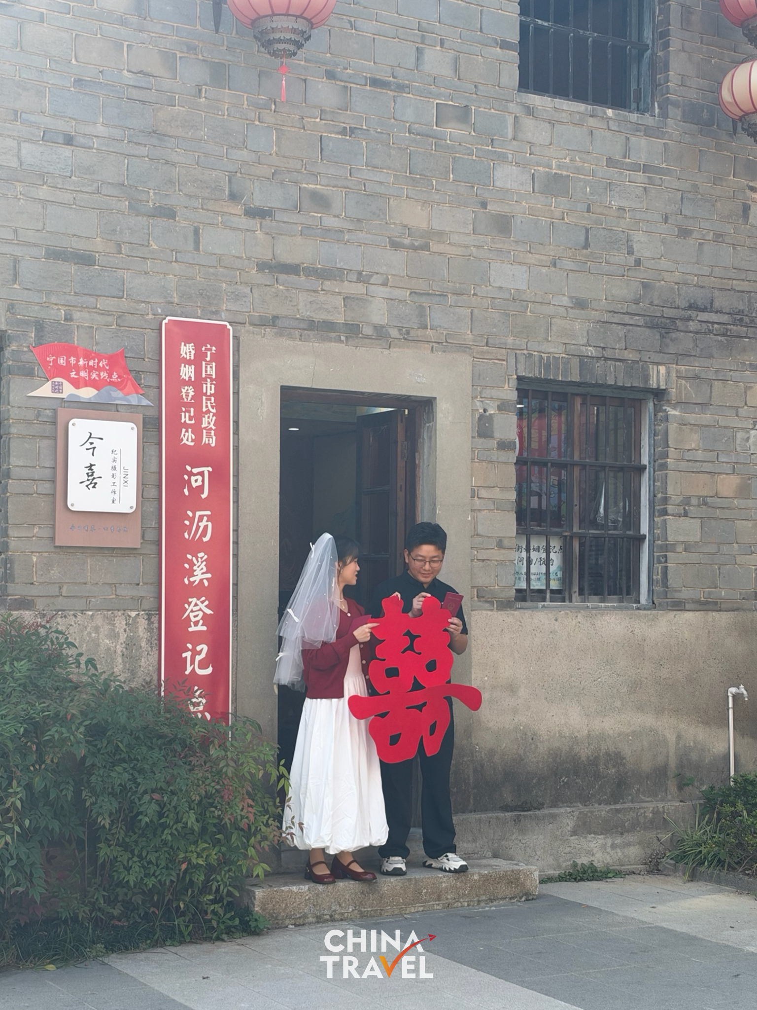 A newlywed couple holding their marriage certificate at the local registry office tucked inside the old street. /CGTN